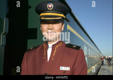 Steward welcomes passengers on board the Tangula Express / Sky Train, from Golmud, Qinghai province, China, to Lhasa, Tibet Stock Photo