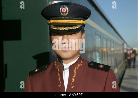 Steward welcomes passengers on board the Tangula Express / Sky Train, from Golmud, Qinghai province, China, to Lhasa, Tibet Stock Photo