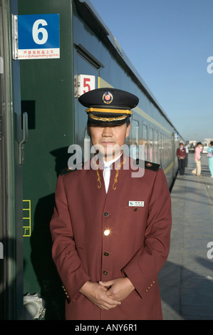 Steward welcomes passengers on board the Tangula Express / Sky Train, from Golmud, Qinghai province, China, to Lhasa, Tibet Stock Photo