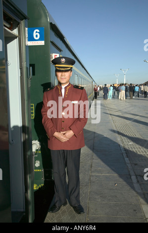 Steward welcomes passengers on board the Tangula Express / Sky Train, from Golmud, Qinghai province, China, to Lhasa, Tibet Stock Photo