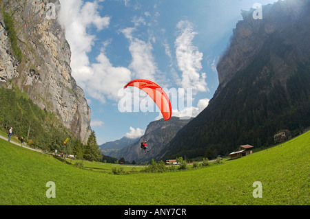 Switzerland, Bernese Oberland, Stechelberg. A paraglider coming in to land at Stechelberg. Stock Photo