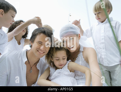 Young married couple surrounded by children Stock Photo