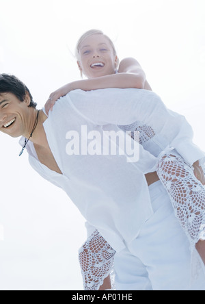 Groom carrying bride piggyback Stock Photo