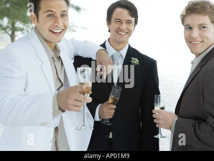 Groom standing with two male friends Stock Photo