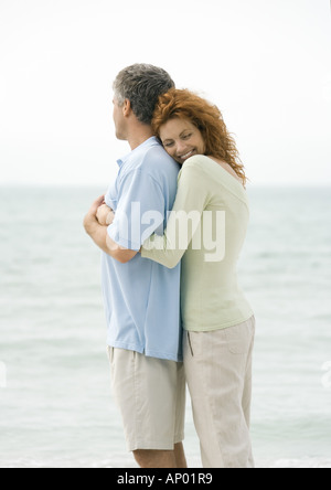 Mature couple, woman hugging man from behind Stock Photo