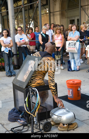 ILLINOIS Chicago Adult male street performer on Michigan Avenue climb into small box in front of crowd of people Stock Photo