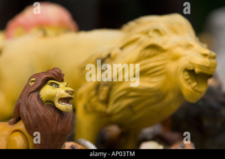 two yellow lion miniature plastic toy figures posed to pounce with mouths open showing teeth Stock Photo