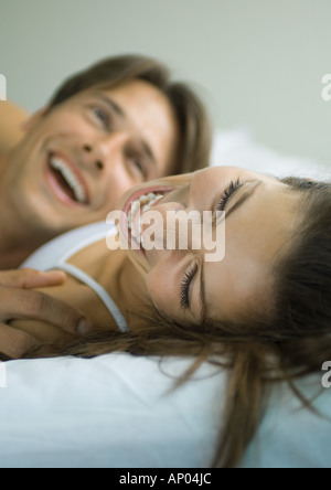 Couple lying in bed, laughing Stock Photo
