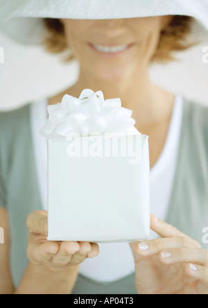 Woman holding out gift Stock Photo