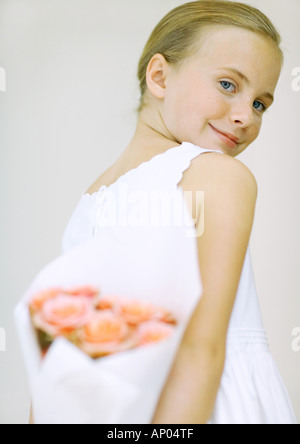 Girl holding bouquet of flowers behind back Stock Photo