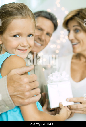 Little girl giving grandparents christmas present Stock Photo