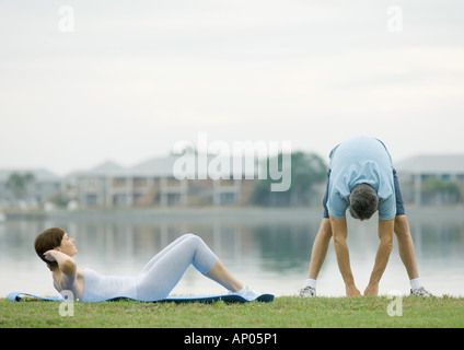 Couple working out by edge of water Stock Photo