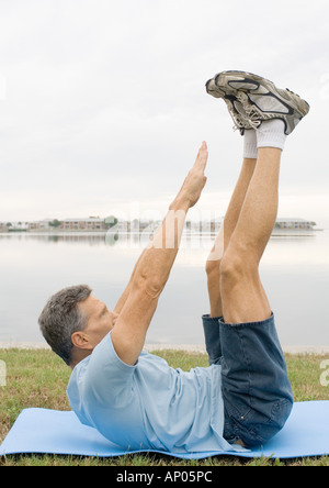 Man doing sit-ups by edge of water