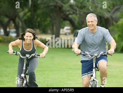 Mature couple riding bikes, front view Stock Photo