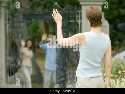Woman waving to neighbors Stock Photo