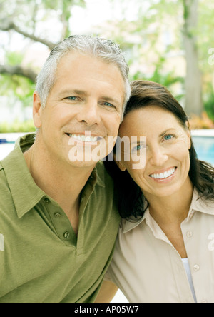 Mature couple smiling, portrait, pool in background Stock Photo