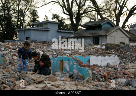 boys playing in a neighbourhood Hutong partially destroyed and marked for demolition Beijing China Stock Photo