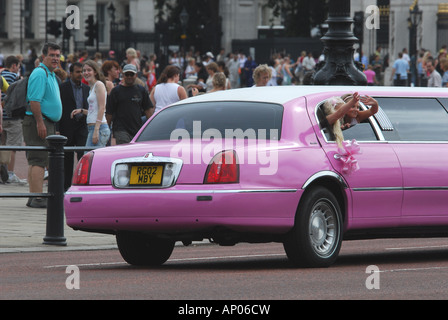 A teenage girl in a stretched limousine waving to the public in London Stock Photo