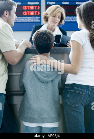 Family standing at airline check-in counter Stock Photo