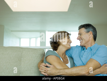 Mature couple embracing on sofa Stock Photo