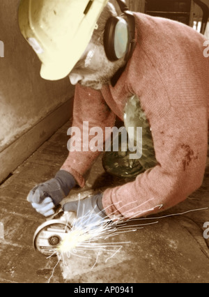 Builder using angle grinder to cut metal Stock Photo