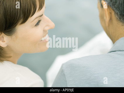 Woman smiling as man reads newspaper Stock Photo