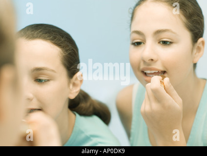 Two teenage girls putting on make-up