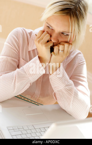 Girl looking worried at work using computer Stock Photo