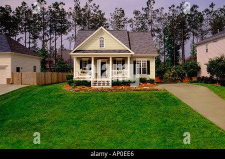 Small Tan House With Black Shutters White Trim And A Large Lawn Stock Photo