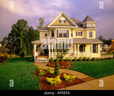 Large Two Story Yellow Victorian House With Blue Shutters And A Large Porch Stock Photo