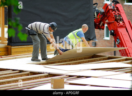 workmen laying wooden floor on construction site Stock Photo
