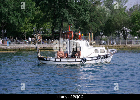 two men enjoying their freetime on their little fishing boat istanbul turkey Stock Photo