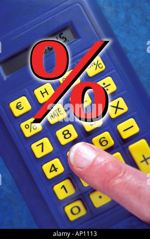Finger on a hand calculator with percentage symbol in foreground Stock Photo