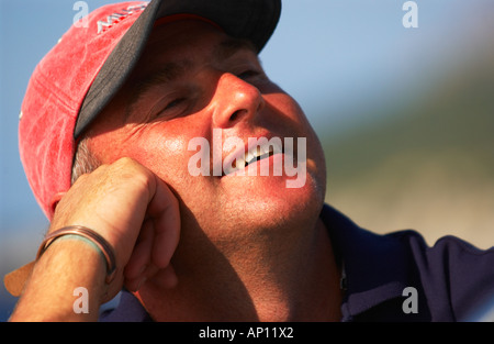 Smiling man leaning on hand, looking up to the right showing happiness and contentment Stock Photo