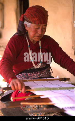 Elderly woman weaving a rug in the village of Pothana in the Annapurna region of Nepal Stock Photo