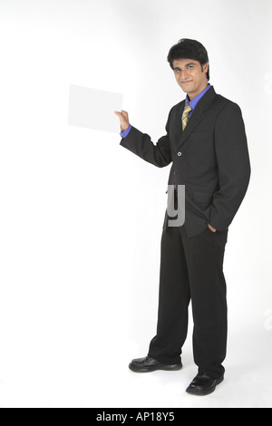 Executive with a black suit standing and holding a blank paper in hand with a smile   Model release Nnumber 687M Stock Photo