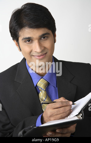 ANG200090 Executive holding diary and pen and smiling Model release No 687M Stock Photo