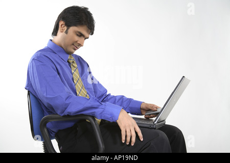 ANG200152 Executive resting on a chair holding laptop on his lap Stock Photo