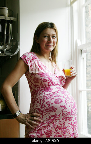 Pregnant woman drinking orange juice Stock Photo