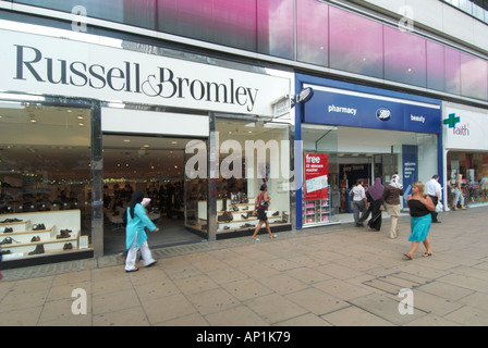 Oxford Street pavement Russell Bromley store adjacent to Boots pharmacy premises with shoppers Stock Photo