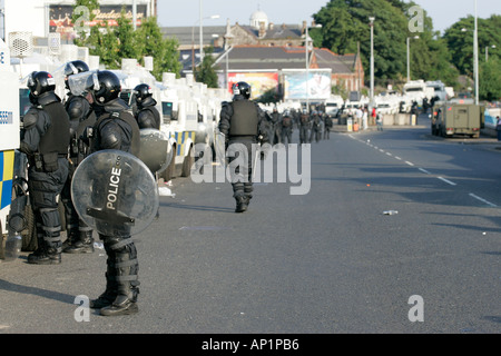 Line of PSNI Officers in riot gear, with armoured landrovers and water ...