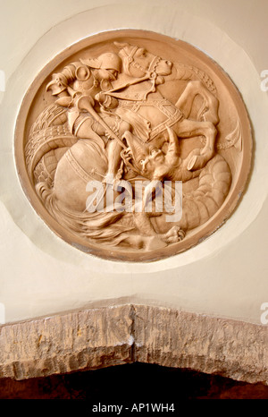 A STONE CARVING OVER A FIREPLACE DEPICTING SAINT GEORGE SLAYING THE DRAGON UK Stock Photo