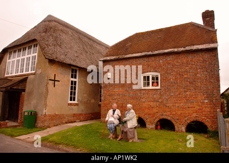 TWO ELDERLY LADIES CHATTING OUTIDE THE VILLAGE SHOP AND POST OFFICE AT BRIANTSPUDDLE IN DORSET UK Stock Photo