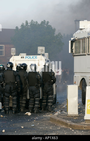 PSNI riot officers behind armoured land rover and water cannon on crumlin road at ardoyne shops belfast 12th July Stock Photo