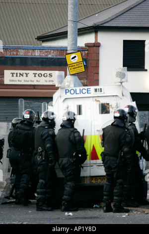 PSNI officers behind armoured land rover under surveillance sign on crumlin road at ardoyne shops belfast 12th July Stock Photo