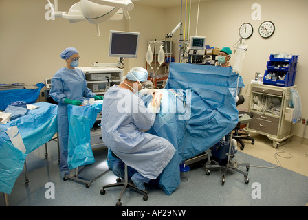 Surgical team performing arthroscopic knee surgery in hospital operating room Stock Photo