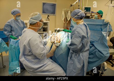 Surgical team performing arthroscopic knee surgery in hospital operating room Stock Photo