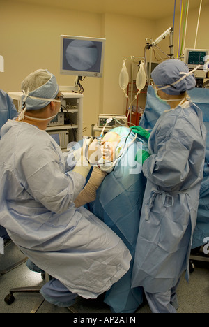 Surgical team performing arthroscopic knee surgery in hospital operating room Stock Photo