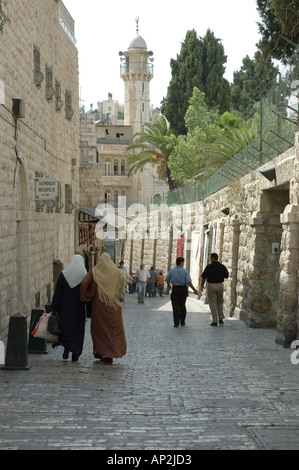 Two Palestinian women walk past the Armenian Hospice in the old city of Jerusalem Israel Stock Photo