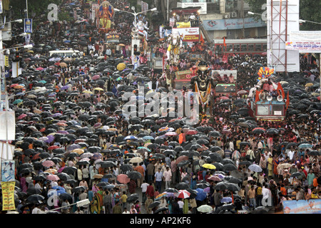 Ganesh festival procession during monsoon rains umbrellas Mumbai Maharashtra India Stock Photo